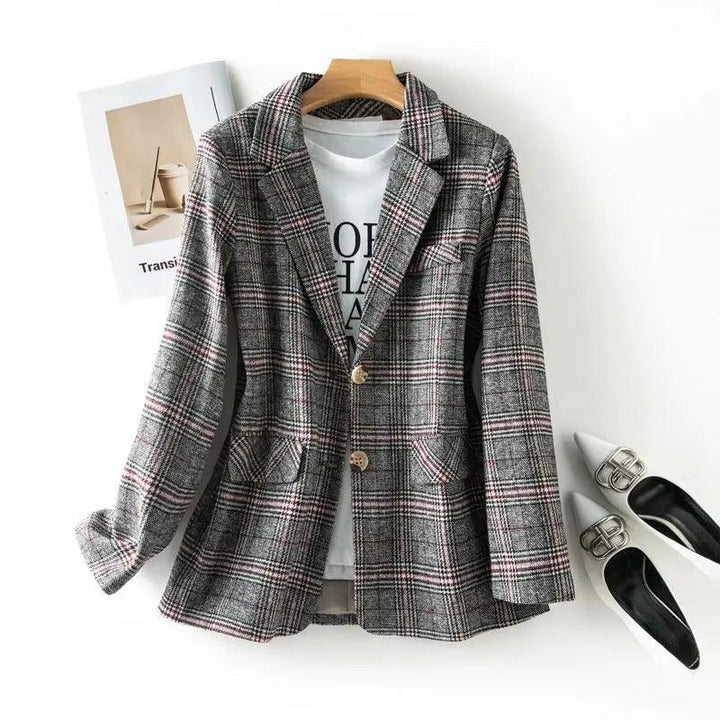Gray plaid blazer with red and white lines, two gold buttons, and flap pockets on a hanger.