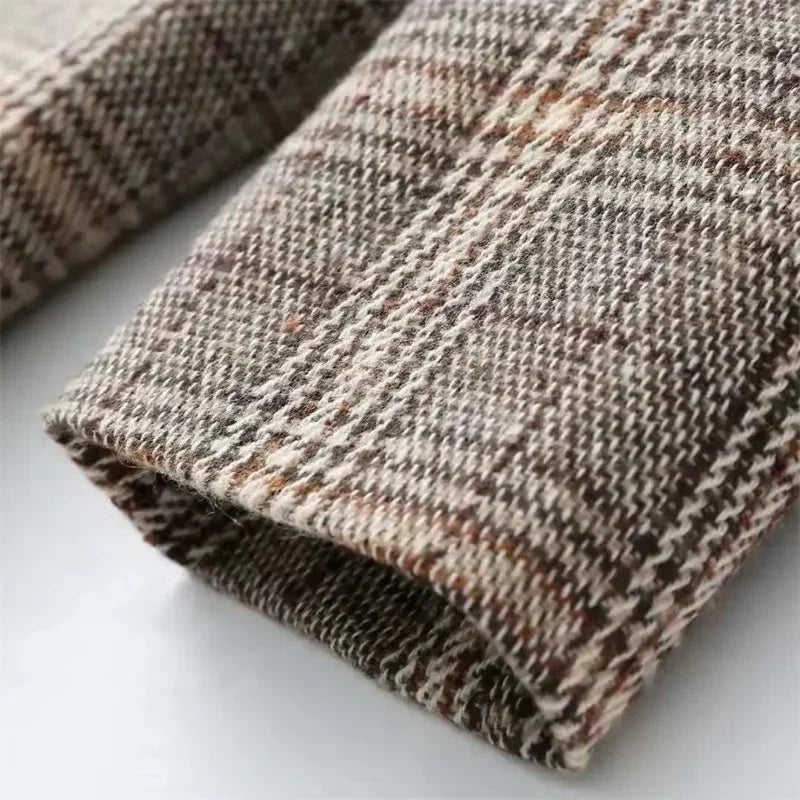 Close-up of a brown and cream plaid fabric with a visible woven texture and subtle flecks of color.