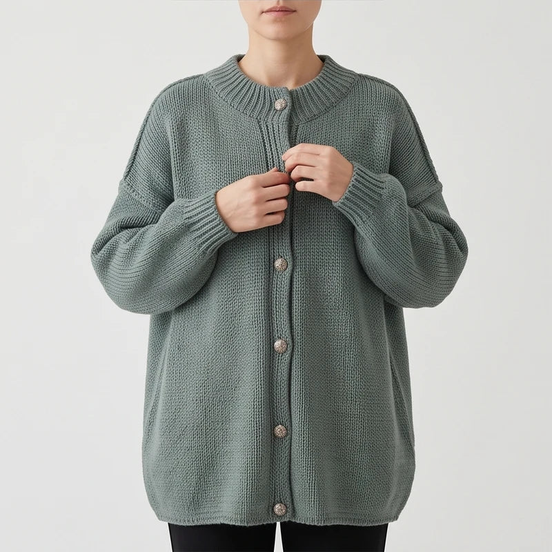 Green knit cardigan on an off-gray studio background
