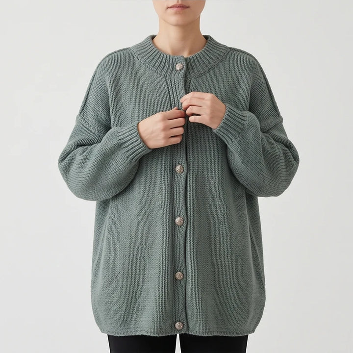 Green knit cardigan on an off-gray studio background