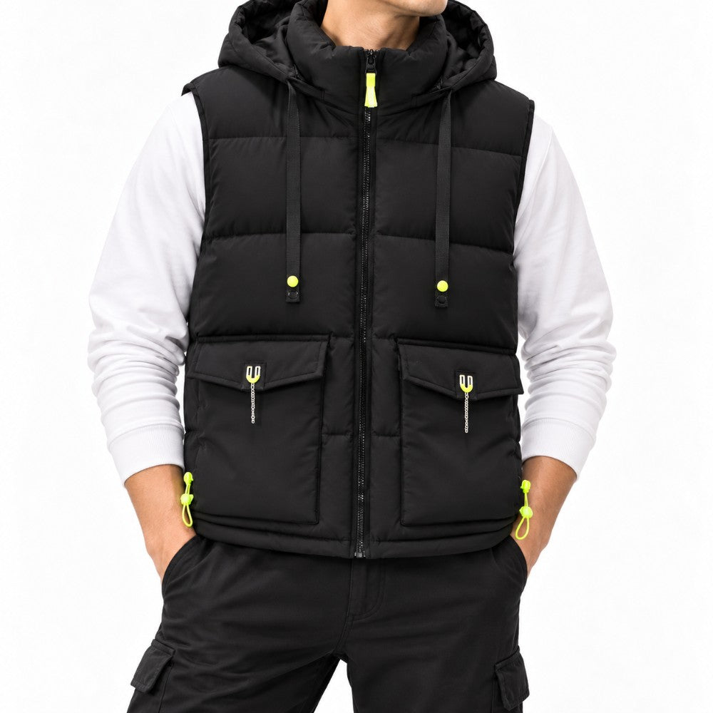 Man wearing a black padded vest with a hood, neon yellow zippers, chest flaps, and front utility pockets.