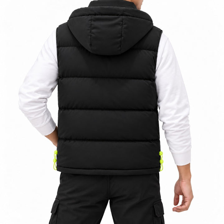 Man wearing a black hooded puffer vest with horizontal quilting, neon green drawstring adjusters, over a white long-sleeve shirt.