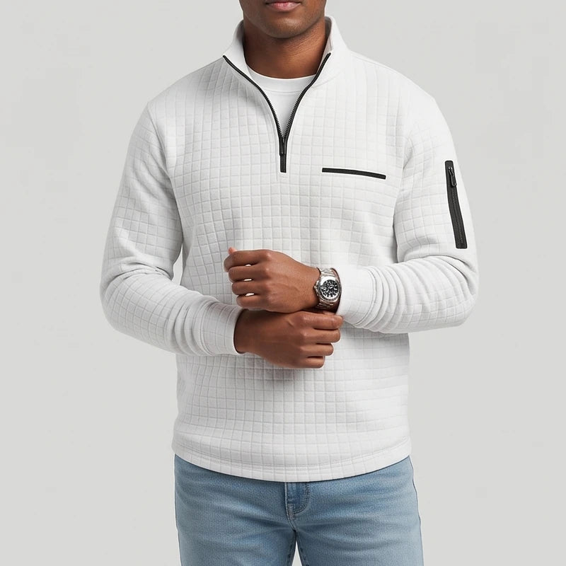 Man wearing a light gray textured quarter-zip pullover with black zippers and a chest pocket, adjusting a watch.