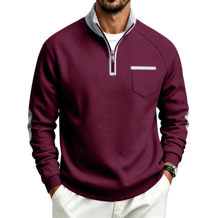 Man wearing a maroon quarter-zip sweatshirt with a gray collar, silver zipper, chest pocket, and gray sleeve stripes.