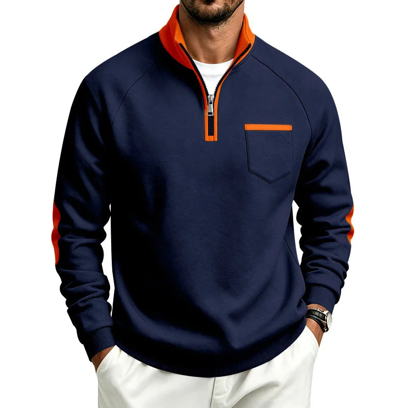 Man wearing a navy blue quarter-zip sweatshirt with an orange collar, zipper trim, chest pocket trim, and arm stripes.