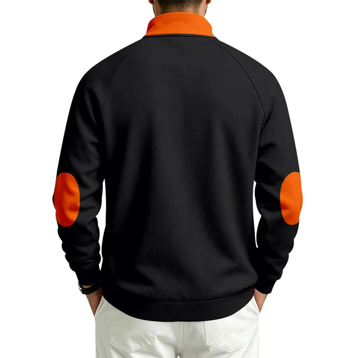 Man wearing a black pullover, back view, with an orange collar and round orange elbow patches.