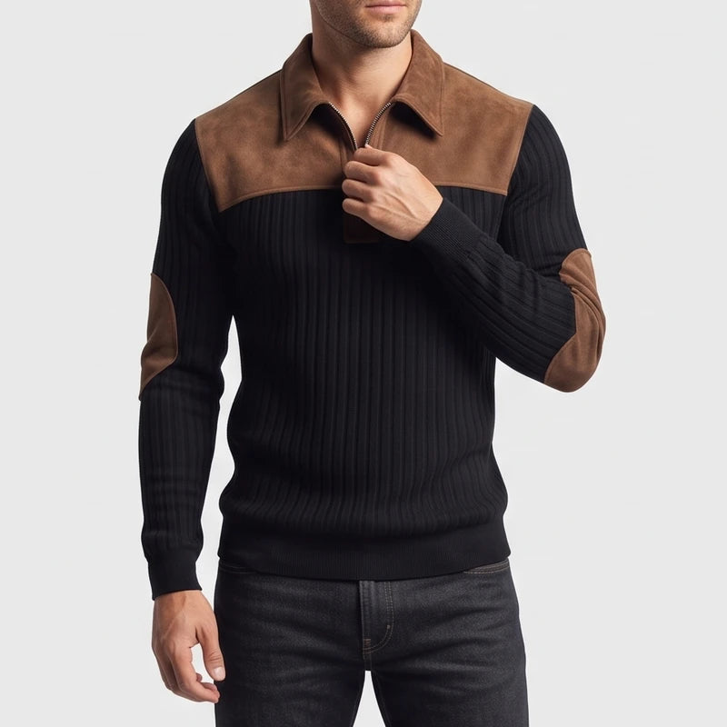 Man wearing a black ribbed quarter-zip sweater with brown suede collar, shoulder, and elbow patches, adjusting the zipper.