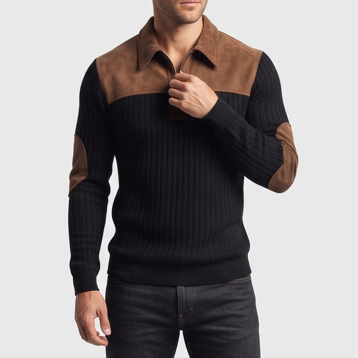 Man wearing a black ribbed quarter-zip sweater with brown suede collar, shoulder, and elbow patches, adjusting the zipper.