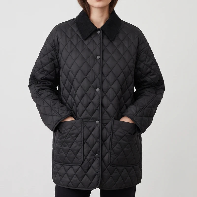 Woman wearing a black quilted jacket with a corduroy collar, button front closure, and hands in two large patch pockets.