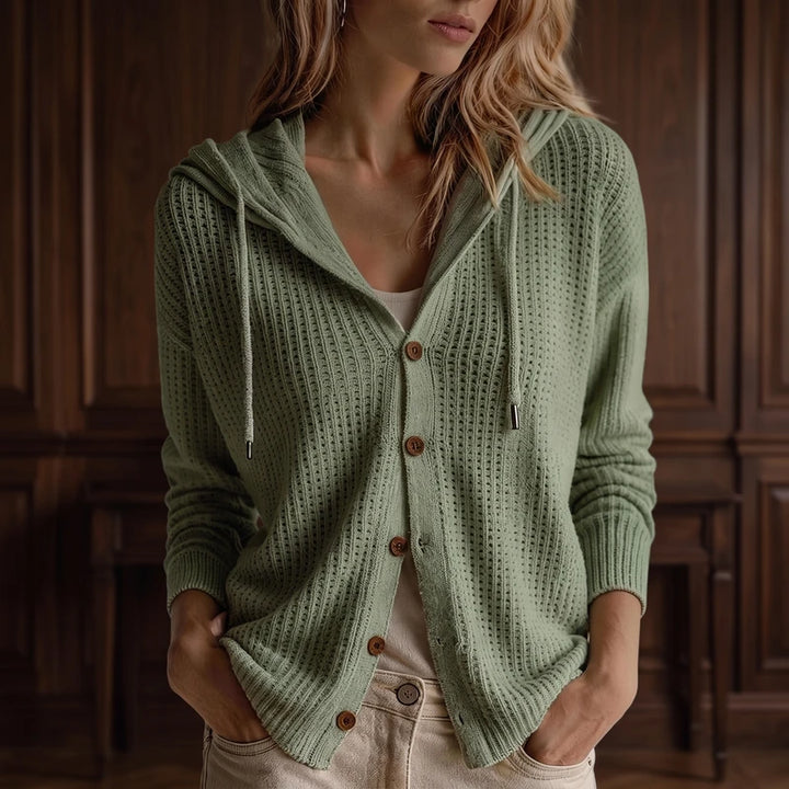Green knit cardigan in a dark wood interior