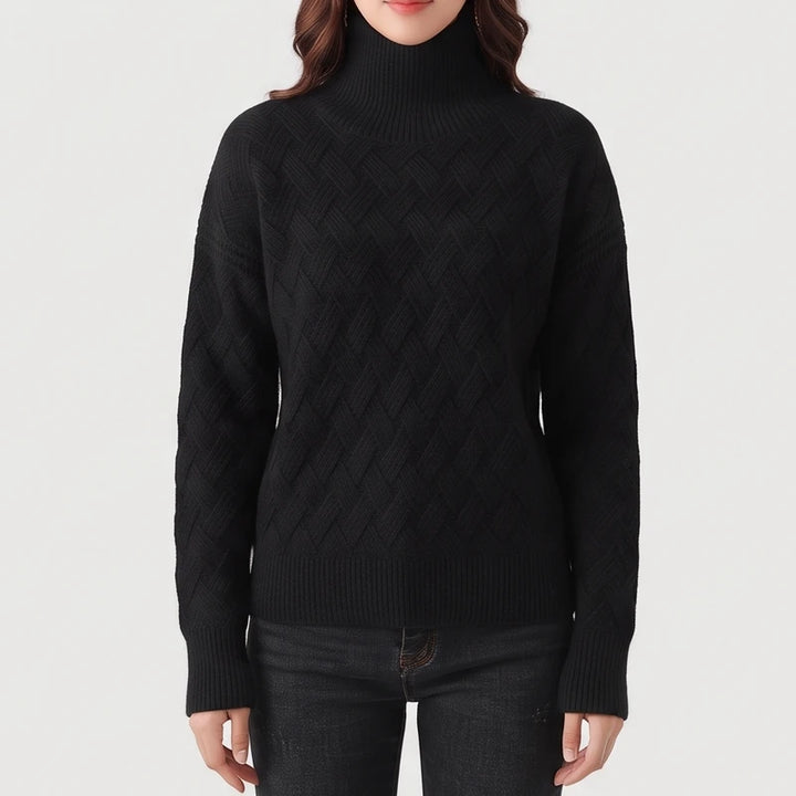 Woman wearing a black textured knit turtleneck sweater with ribbed cuffs and hem, paired with dark denim jeans.