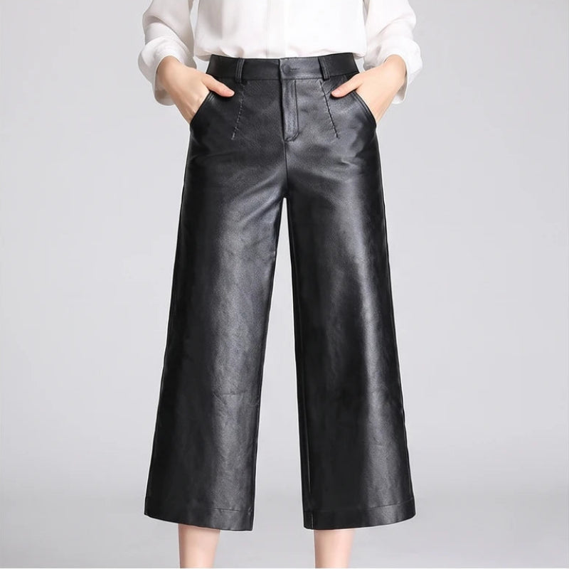 Black leather pants on an off-gray studio background