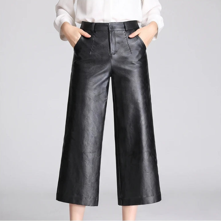 Black leather pants on an off-gray studio background