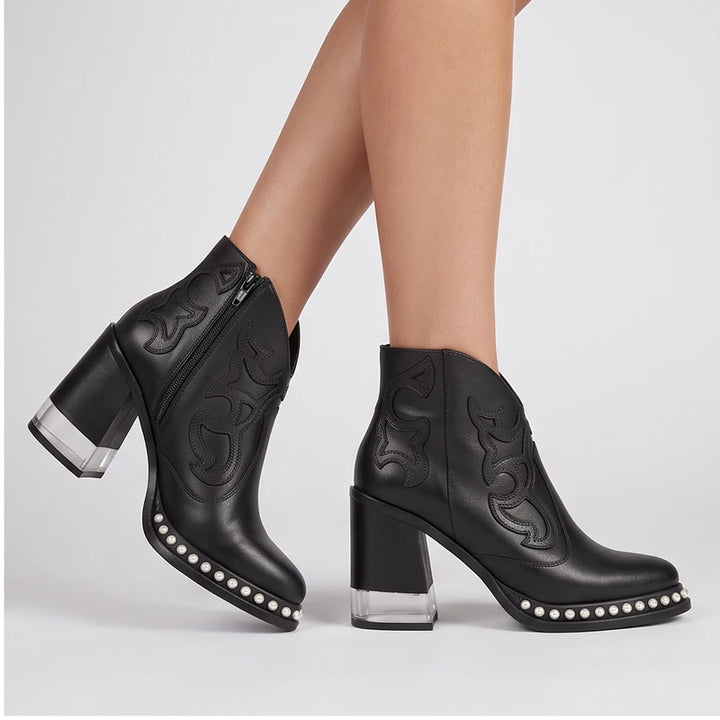 Model wearing Black leather boots in a studio