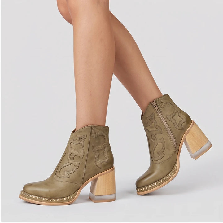 Model wearing Khaki leather boots in a studio