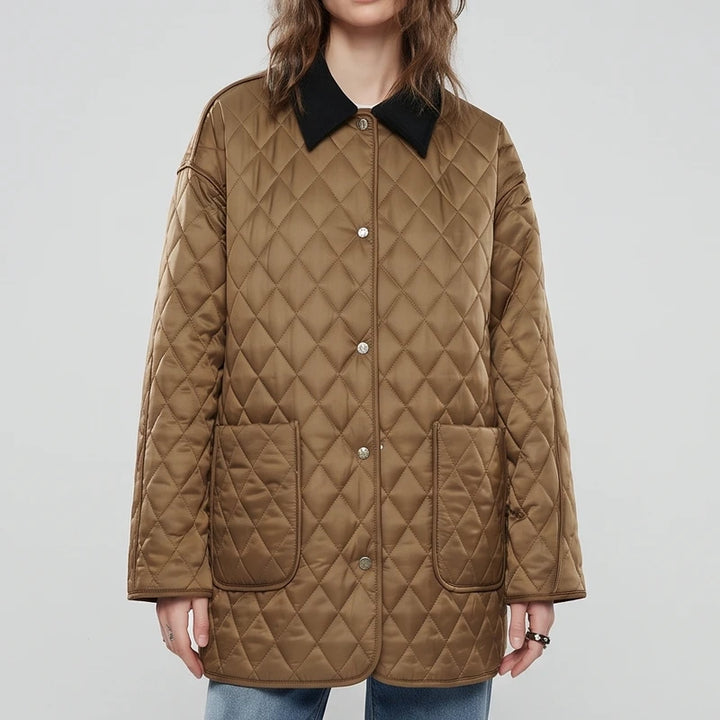 Woman wearing a relaxed-fit, quilted brown jacket with a black collar, front snap buttons, and two large pockets.