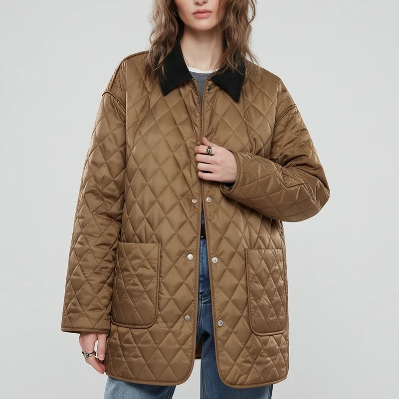 Woman wearing a brown quilted jacket with a black corduroy collar, silver snap buttons, and two front patch pockets.