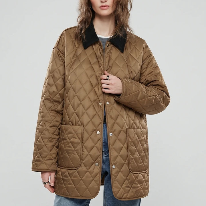 Woman wearing a brown quilted jacket with a black corduroy collar, silver snap buttons, and two front patch pockets.