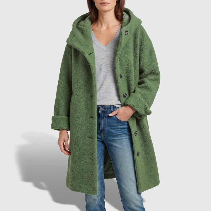 Green coat on an off-gray studio background