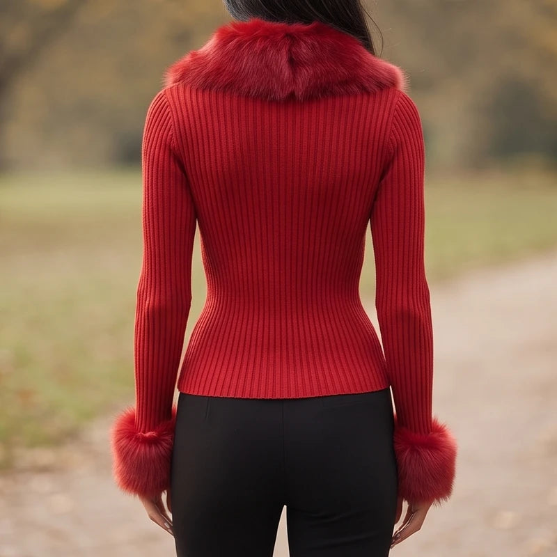 Woman wearing a red ribbed knit sweater with faux fur collar and cuffs, viewed from the back outdoors.