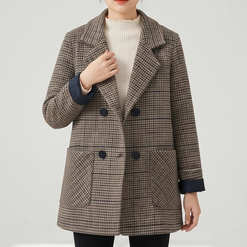 Woman wearing a brown and black houndstooth double-breasted blazer with dark buttons, paired over a cream turtleneck.