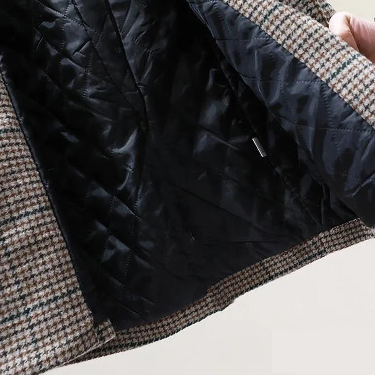 Close-up of a blazer's interior showing a black quilted lining and brown, black, and white houndstooth outer fabric.