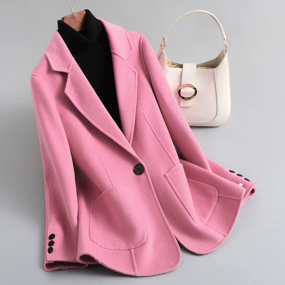 Pink wool coat with a single black button, lapel collar, front patch pockets, and three cuff buttons.