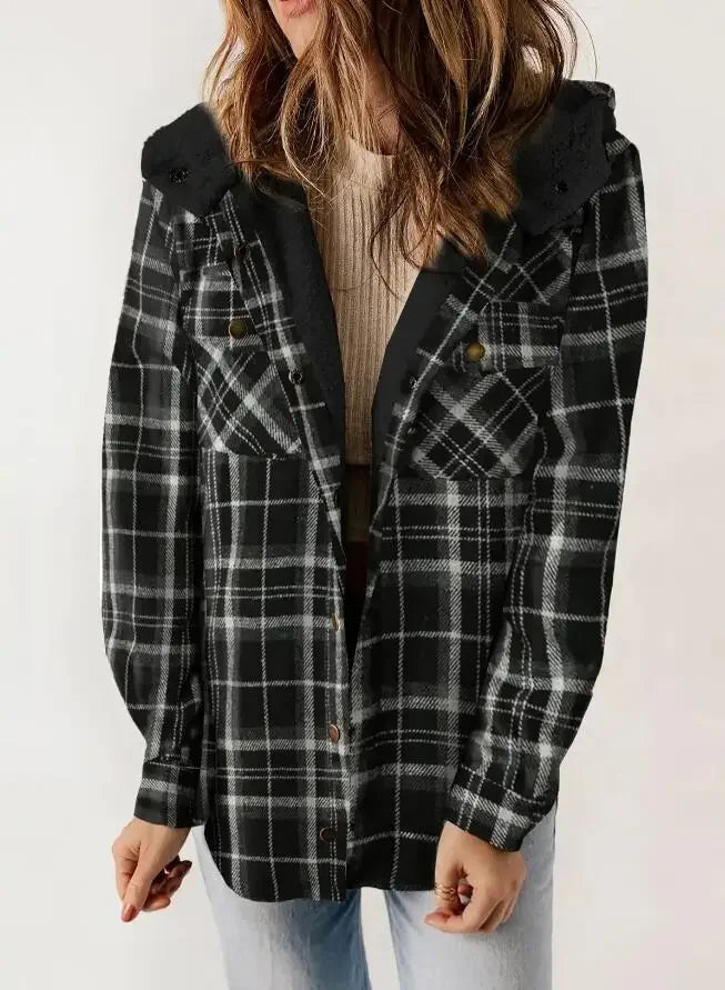 Woman wearing a black and white plaid shacket with a black sherpa-lined hood, over a ribbed beige top.