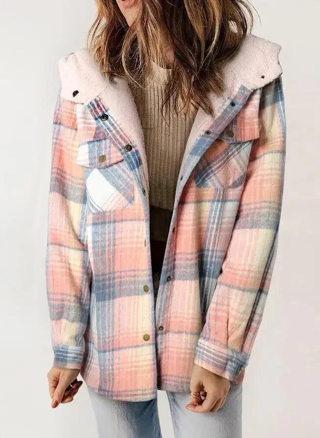 Woman wearing an open pink, blue, and yellow plaid jacket with a sherpa-lined hood over a tan ribbed top.