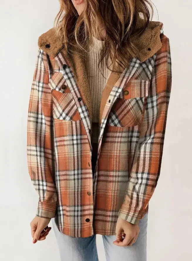 Woman wearing an open orange and beige plaid jacket with a fuzzy brown hooded lining over a ribbed top.