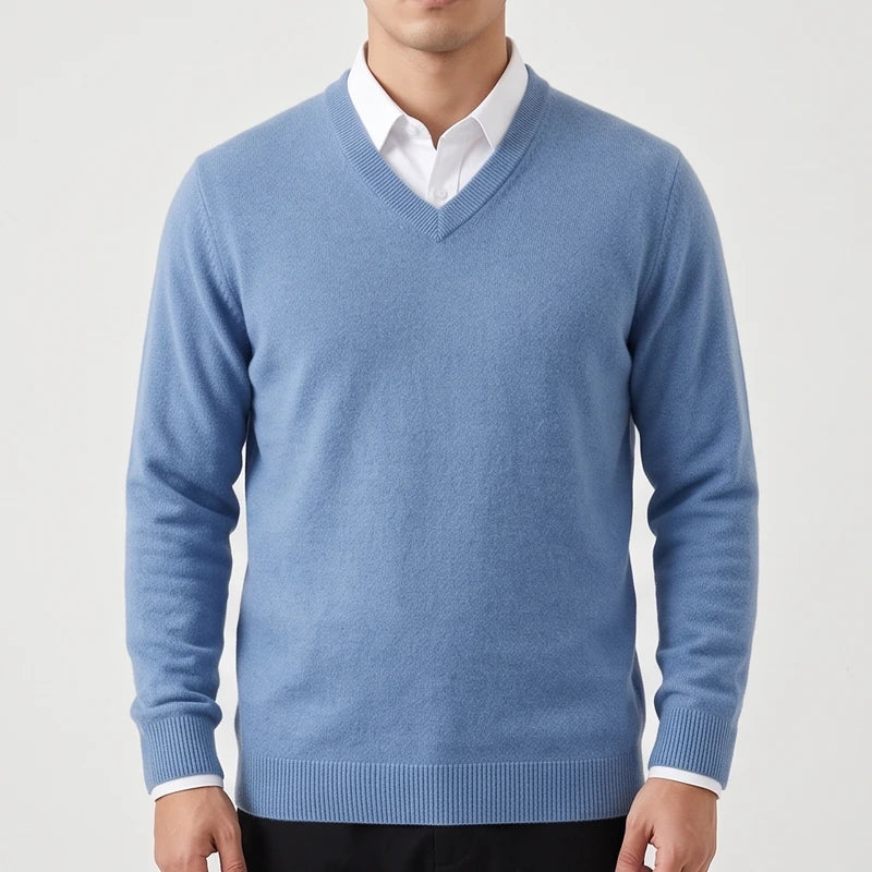 Man wearing a light blue V-neck wool sweater with ribbed trim layered over a white collared dress shirt.