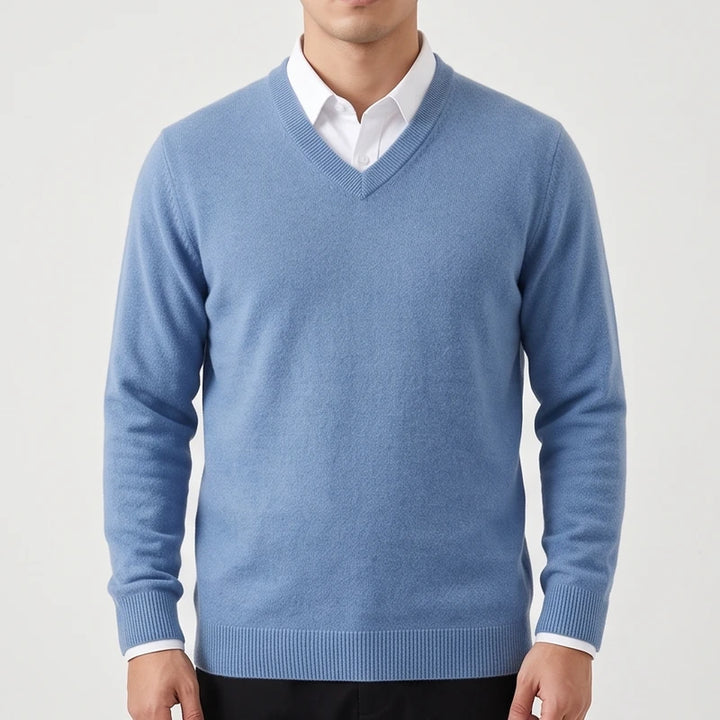 Man wearing a light blue V-neck wool sweater with ribbed trim layered over a white collared dress shirt.
