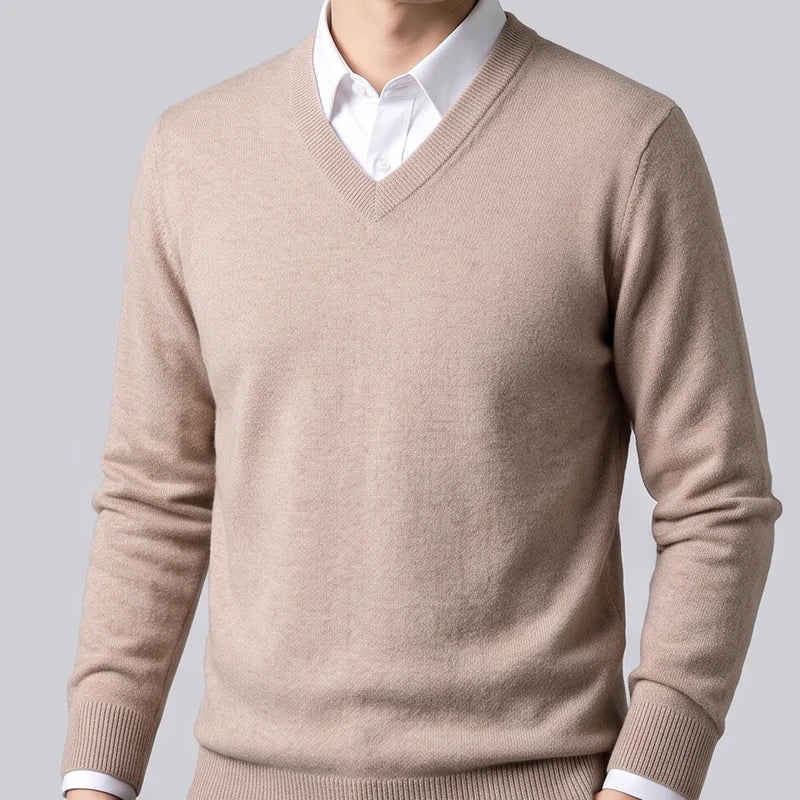 Man wearing a beige wool v-neck sweater with ribbed trim layered over a white collared button-down shirt.