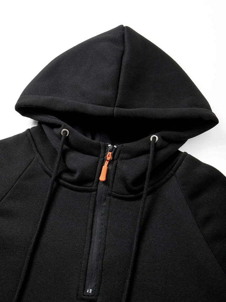 Close-up of a black fleece hoodie showing the hood, orange zipper pull, and black drawstring with silver eyelets.