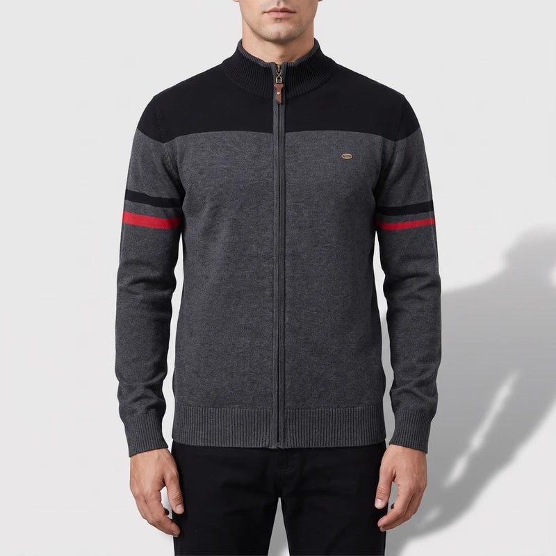 Man wearing a dark gray full-zip sweater with a black yoke, black and red stripes on the sleeves, and a ribbed collar.