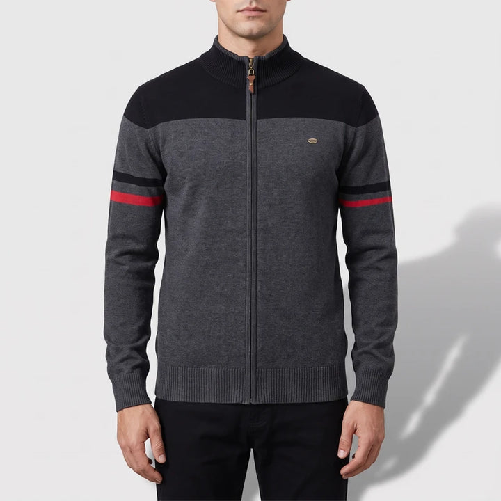 Man wearing a dark gray full-zip sweater with a black yoke, black and red stripes on the sleeves, and a ribbed collar.