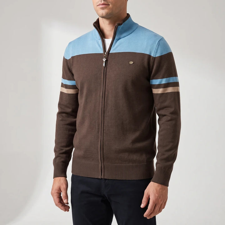 Man wearing a brown zip-up sweater with light blue and beige stripes on the chest and sleeves, against a white background.