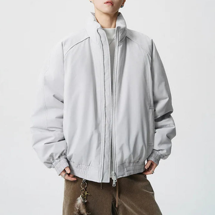 Person wearing a light gray jacket on a white background